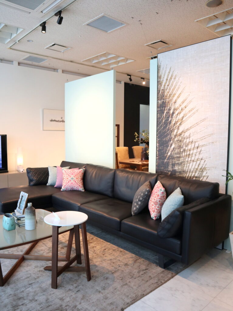 黒い革のソファには壁紙でインパクトを ウィンドウディスプレイ Domani ドマーニ カリモク家具の最高峰インテリアブランド
